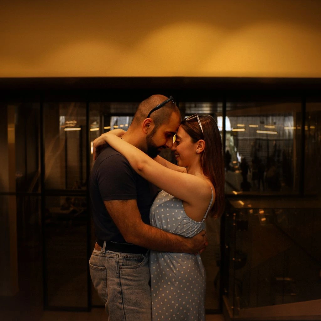 A close-up of two dancers in a quiet embrace during a beginner lesson.